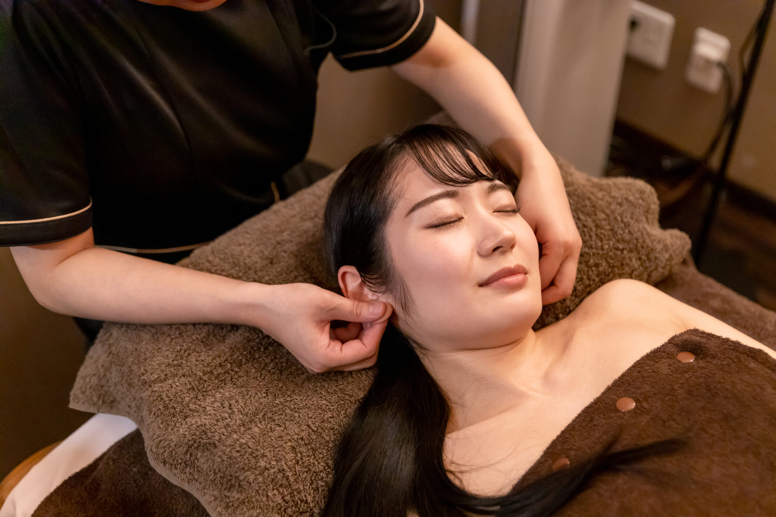 耳のマッサージを受ける女性
